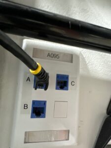 Photo of voice and data cabling jack with black patch cable plugged in