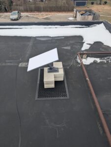 Starlink Antenna installed on cinder blocks on rooftop